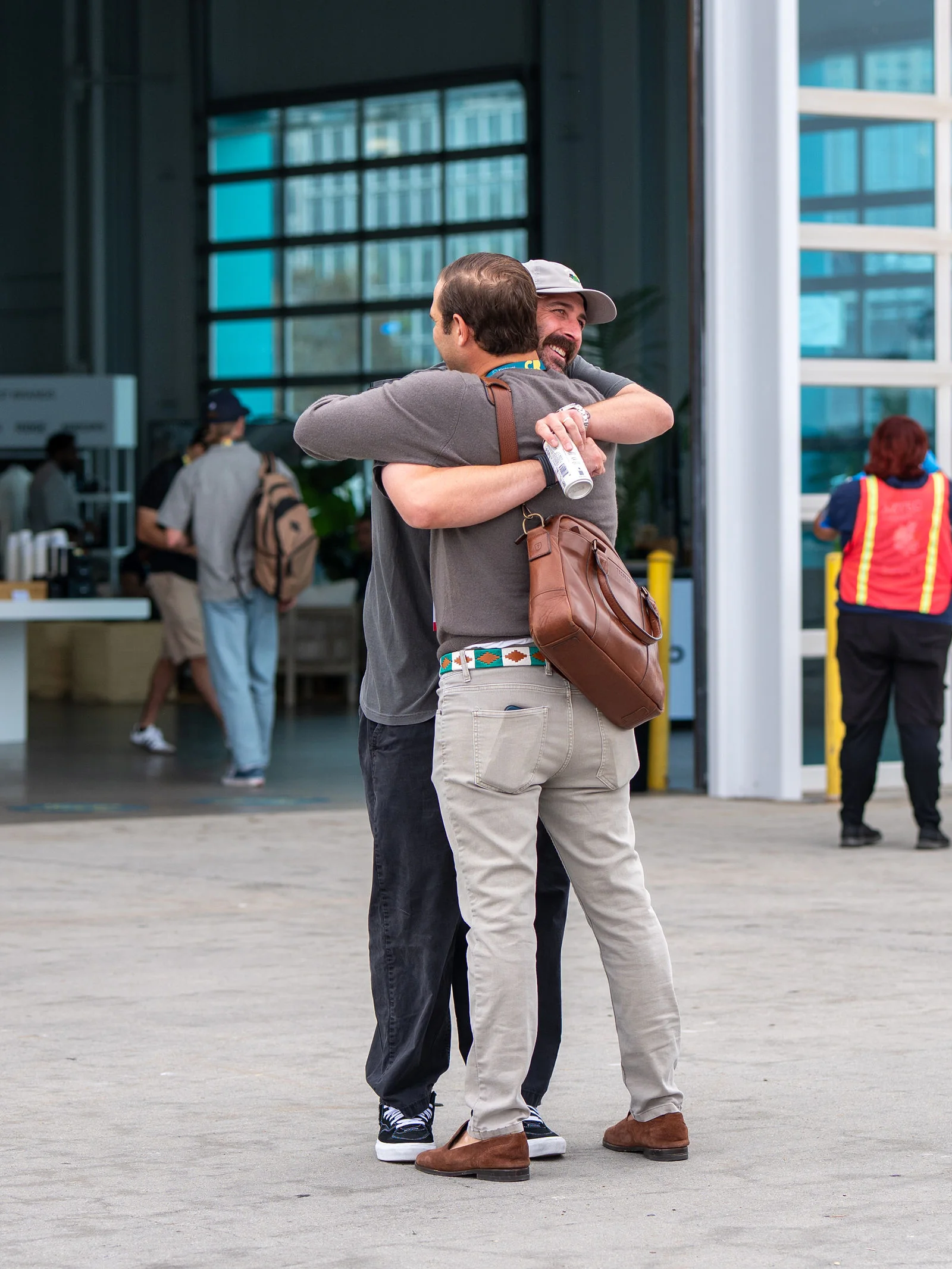 Two attendees greeting each other with a hug outside the San Diego venue